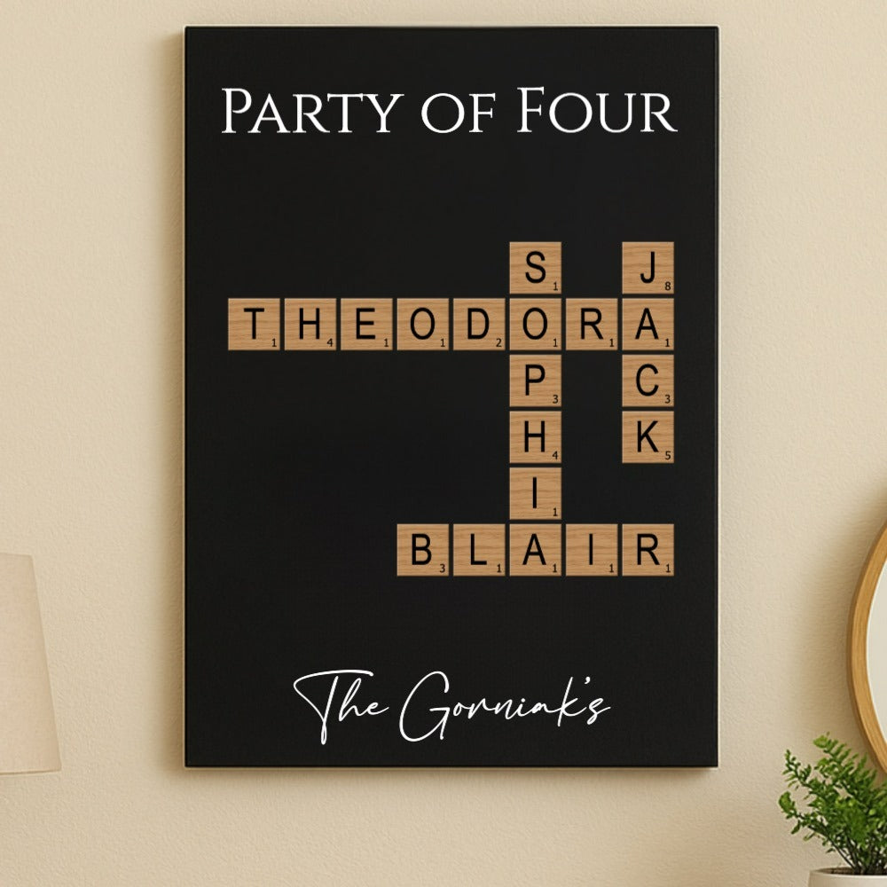 Black wall art displaying "Party of Four" with wooden Scrabble-style tiles showing sample names "Theodora," "Sophia," "Jack," "Sophia," and "Blair" arranged in crossword pattern, personalized family name sign with "The Gorniaks" script at bottom.