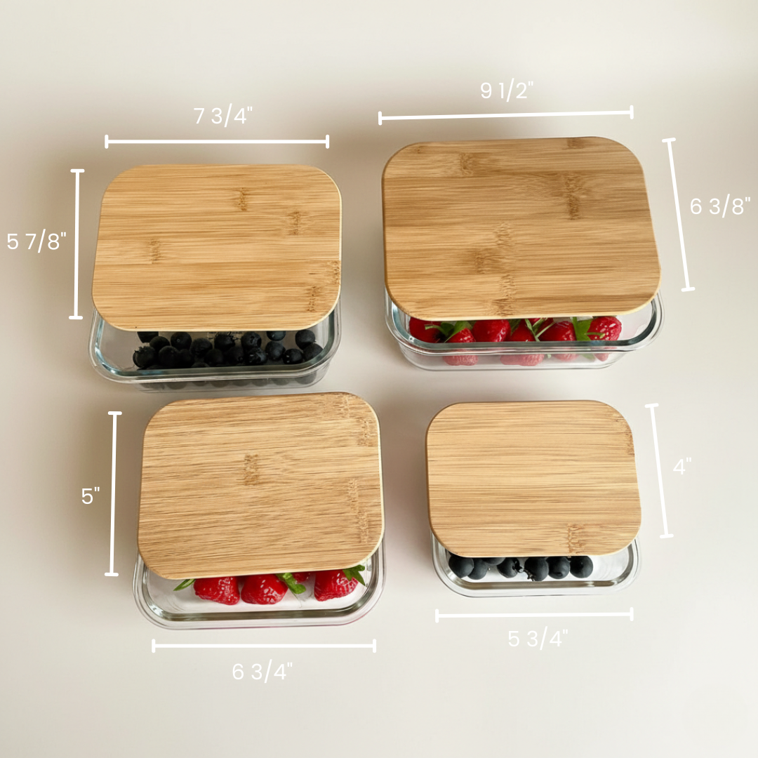 Four glass food storage containers with bamboo lids in graduated sizes, displaying dimensional measurements and sample contents of berries and fruit