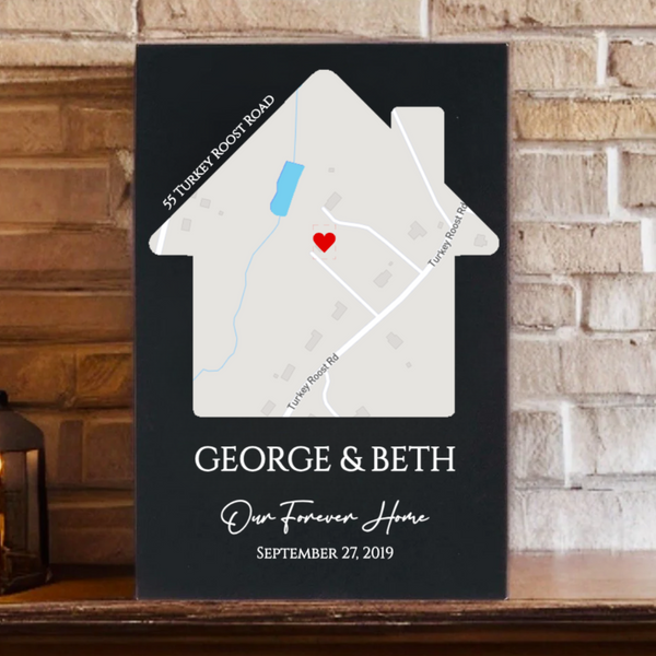 Black house-shaped sign with map showing sample address "55 Turkey Roost Road" and red heart marker, personalized with names "GEORGE & BETH," text "Our Forever Home," and date "SEPTEMBER 27, 2019