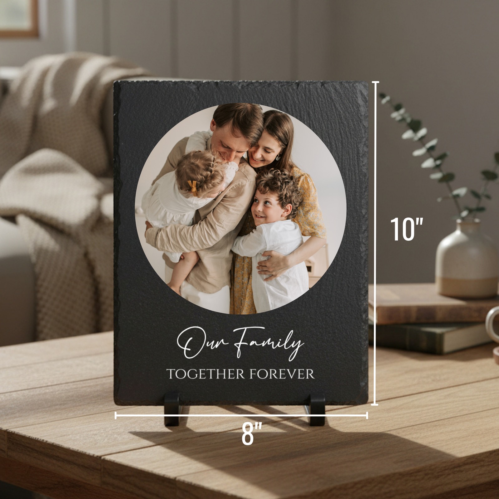 Black slate plaque with circular photo of family with two children, engraved with sample text "Our Family" and "Together Forever," displayed on wooden surface with stands showing 10" x 8" dimensions