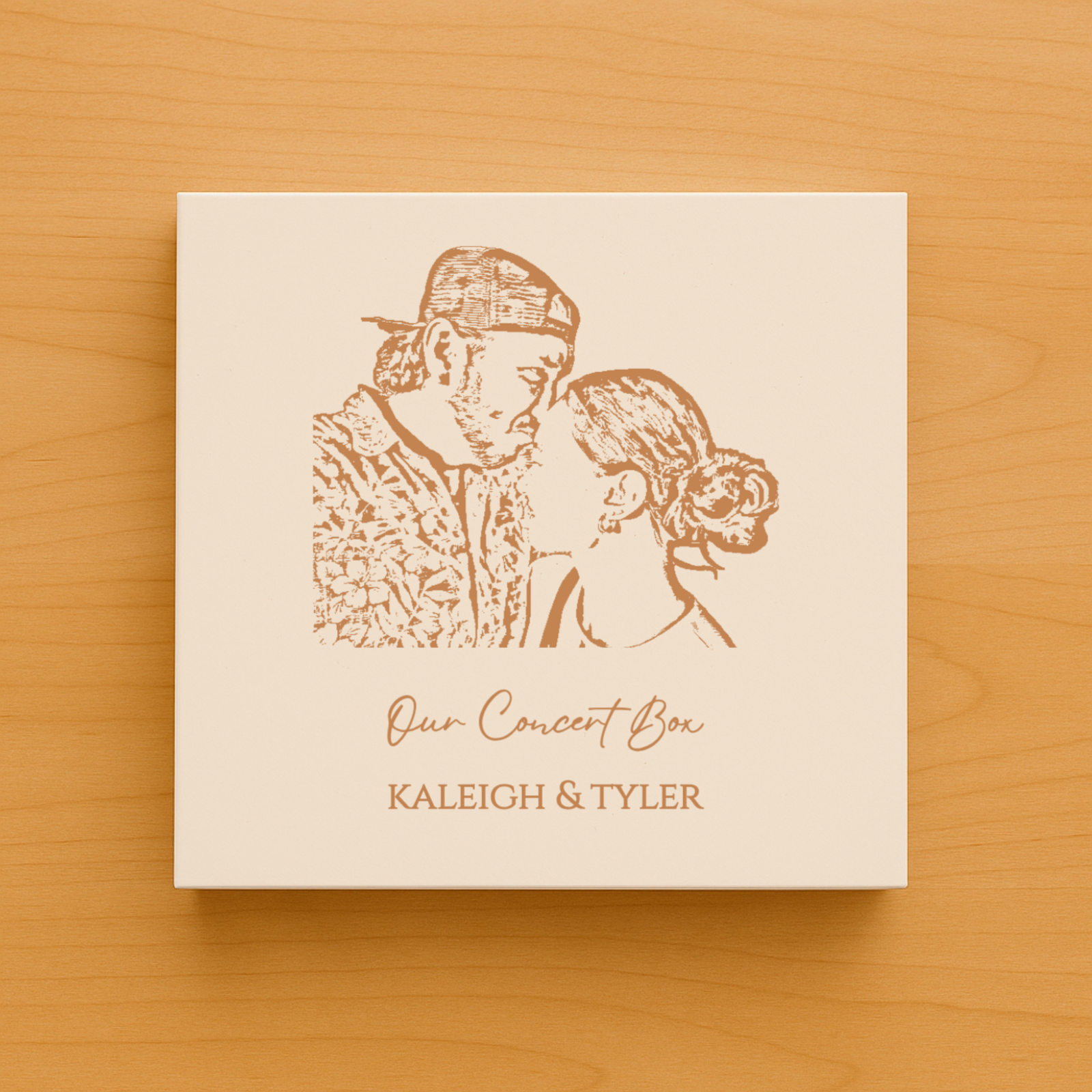 Cream-colored keepsake box with laser-engraved portrait of two people and text reading "Our Concert Box" and sample names "KALEIGH & TYLER