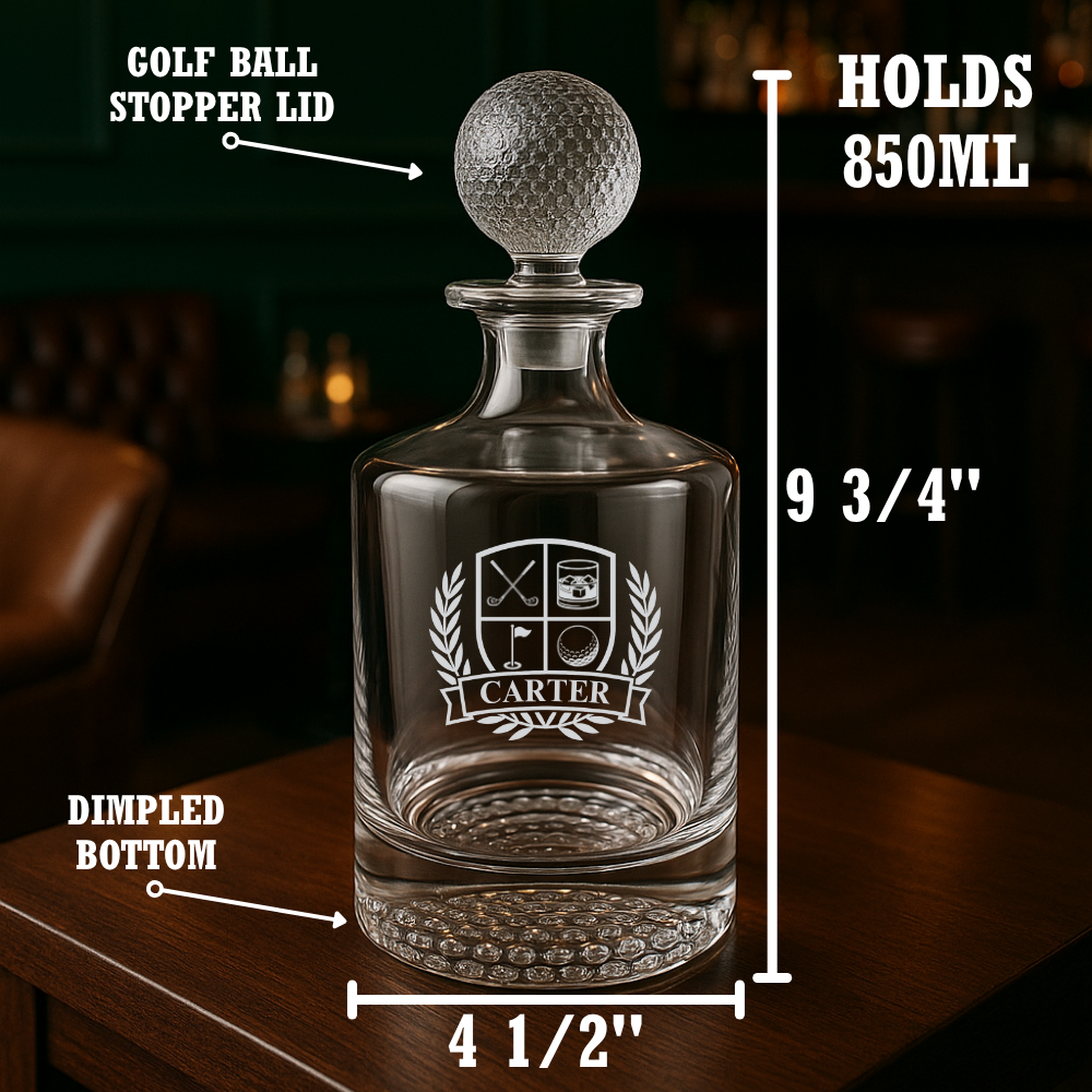 Whiskey decanter with golf ball-shaped stopper, laser-etched golf crest with sample name "CARTER" on laurel banner, dimpled base, 850ml capacity, 9 3/4" tall.