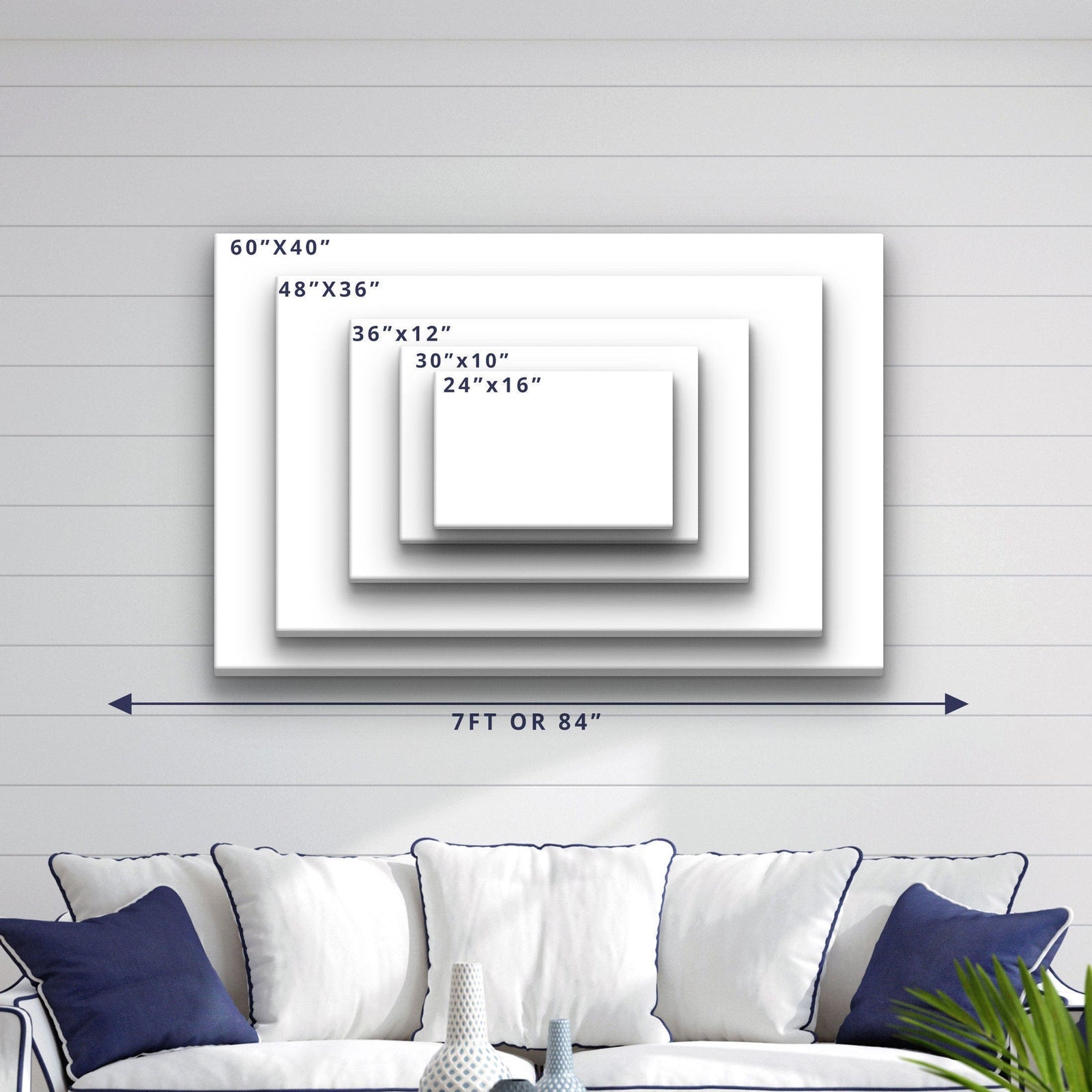 Size comparison chart showing five canvas options ranging from 24"×16" to 60"×40", displayed on shiplap wall above a navy and white upholstered sofa