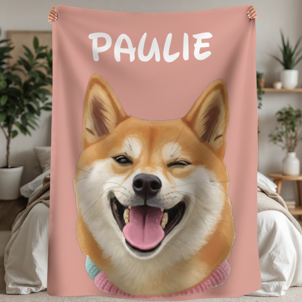 Pink sherpa blanket with cartoon portrait of a smiling tan and white corgi, printed with sample name "PAULIE" above the dog's head