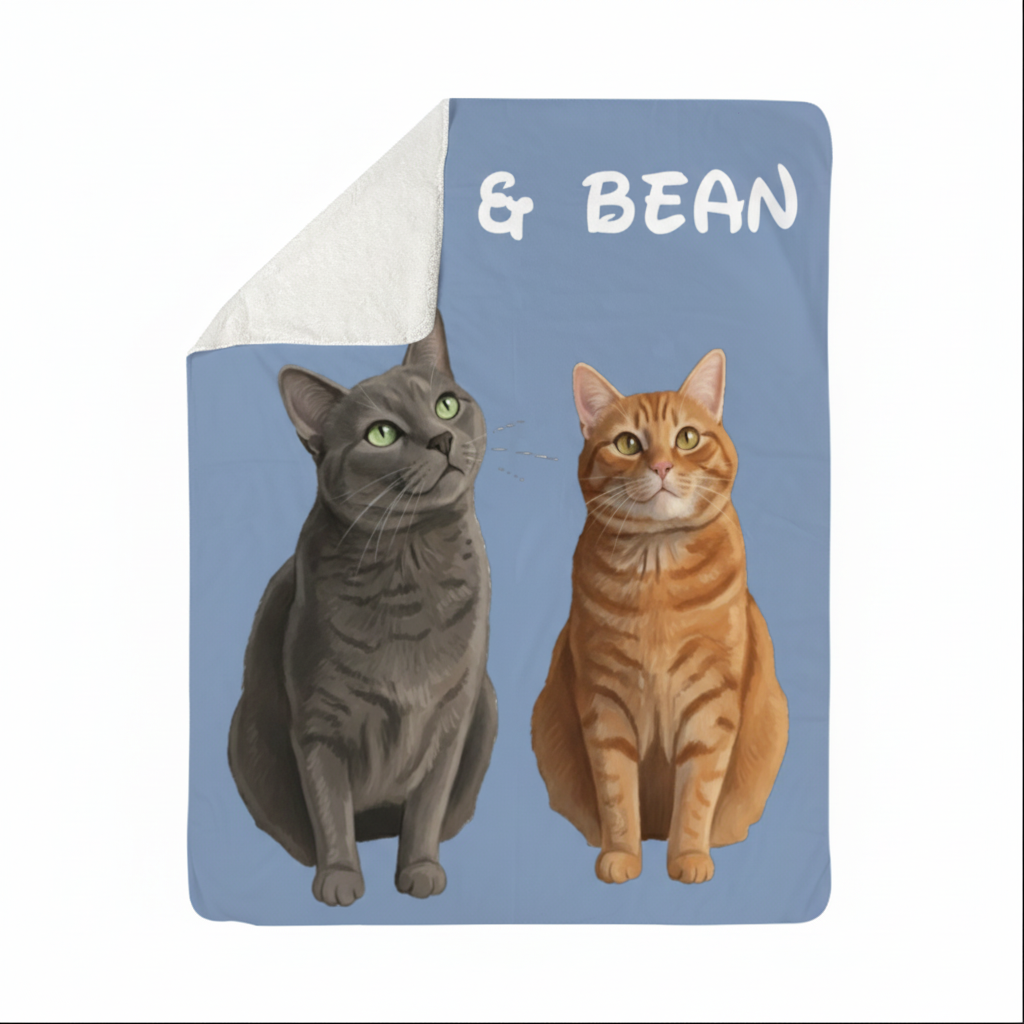 Sherpa blanket with sample cartoon portraits of a gray tabby cat and orange tabby cat labeled "& BEAN" on blue background, showing white fleece reverse side folded back