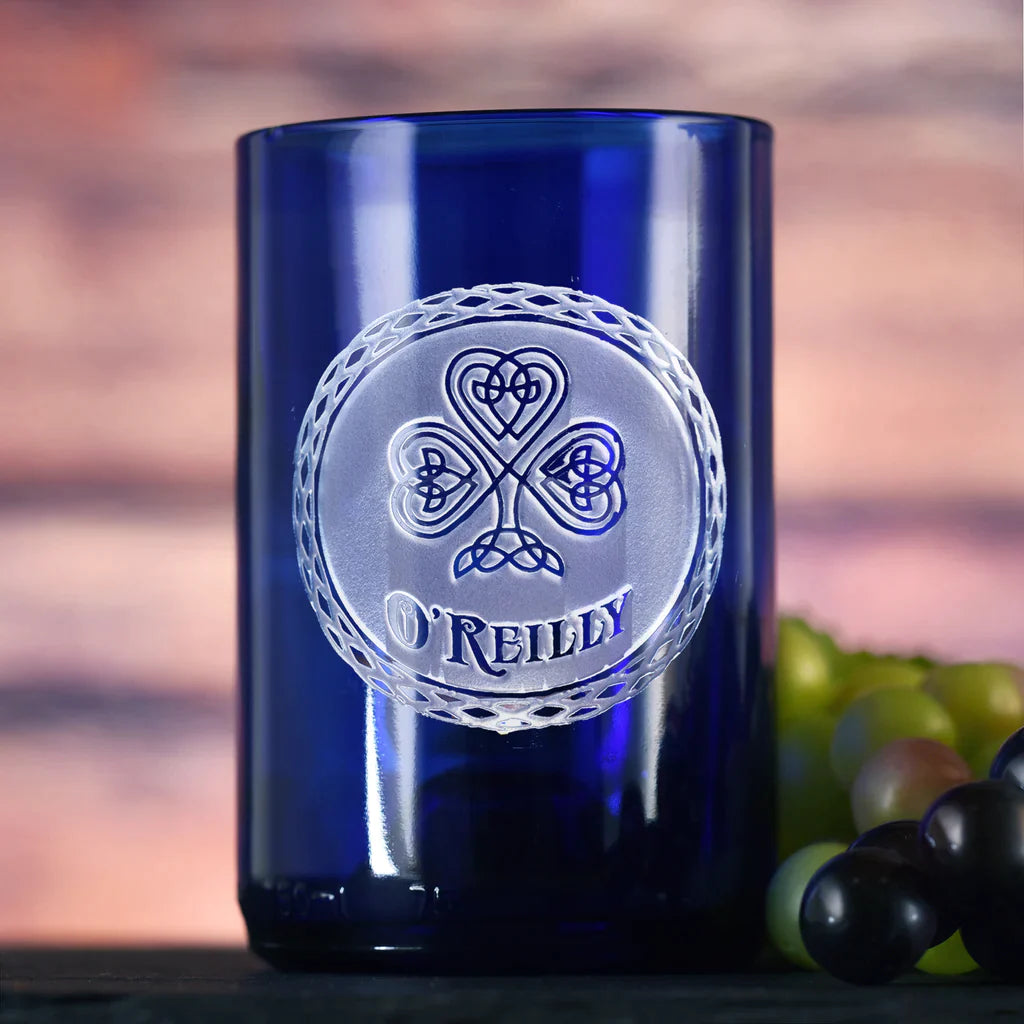 Deep blue recycled wine bottle glass with hand-carved Celtic clover and knotwork design featuring engraved sample name "O'REILLY" in circular medallion