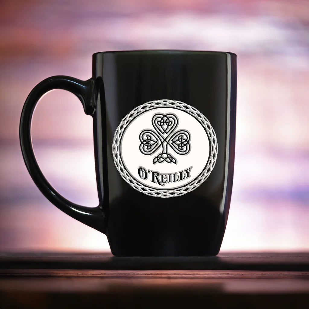 Black ceramic mug with Celtic clover design and "O'REILLY" engraved in white circular medallion with braided border