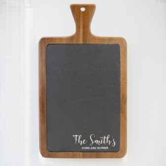 Acacia wood serving board with slate inlay, engraved with sample name "The Smiths" in white script text