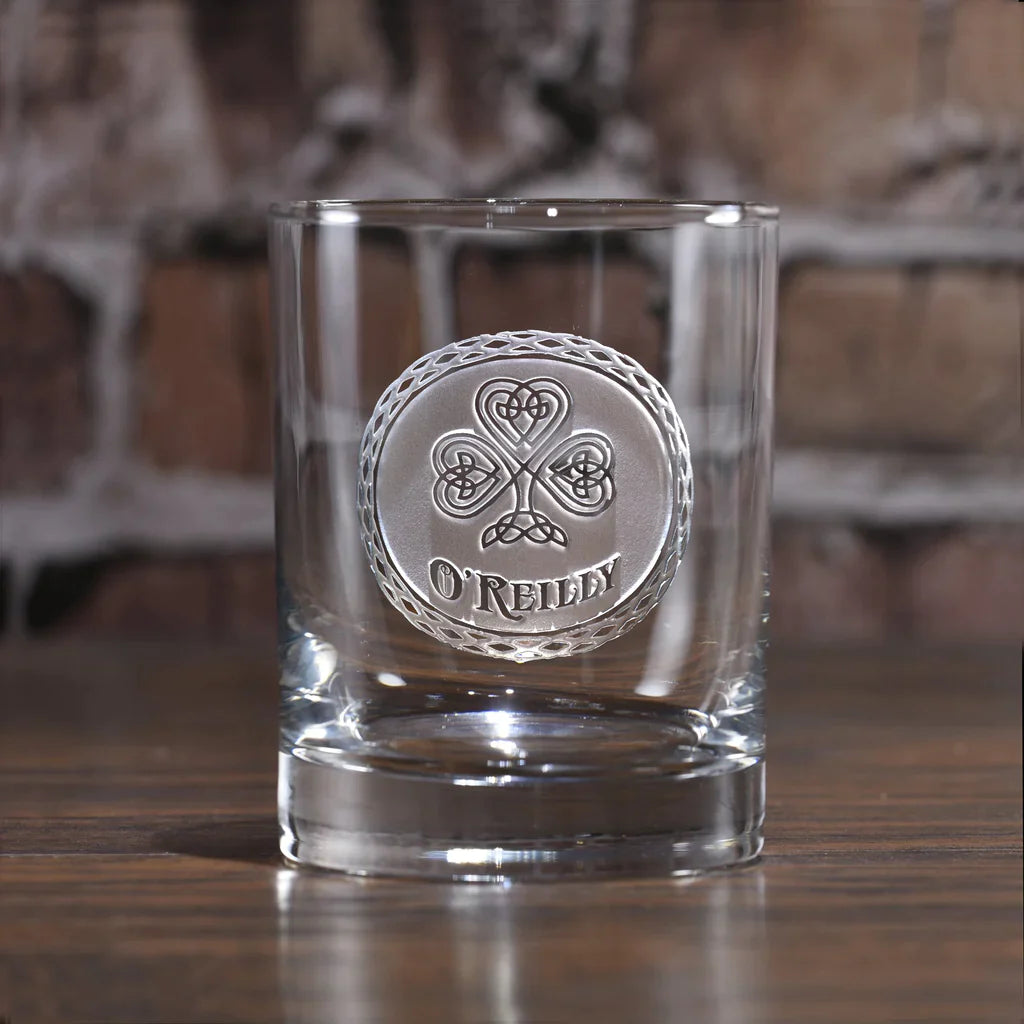 Clear whiskey glass with sand-carved Celtic shamrock design and ornate border, engraved with sample name "O'REILLY" below the symbol