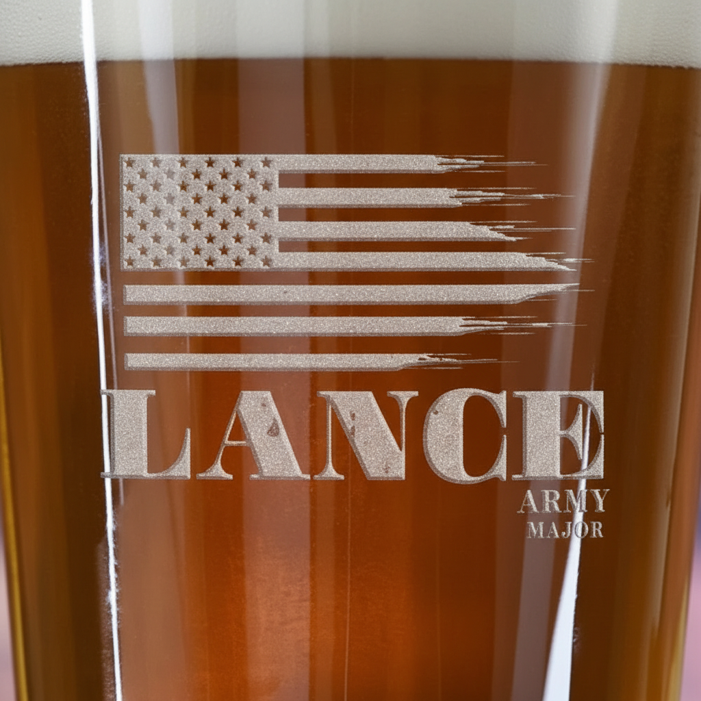 Close-up macro of American Heroes Personalized Pint Glass showing the sand-carved 3D depth of the tattered American flag with service member name and branch