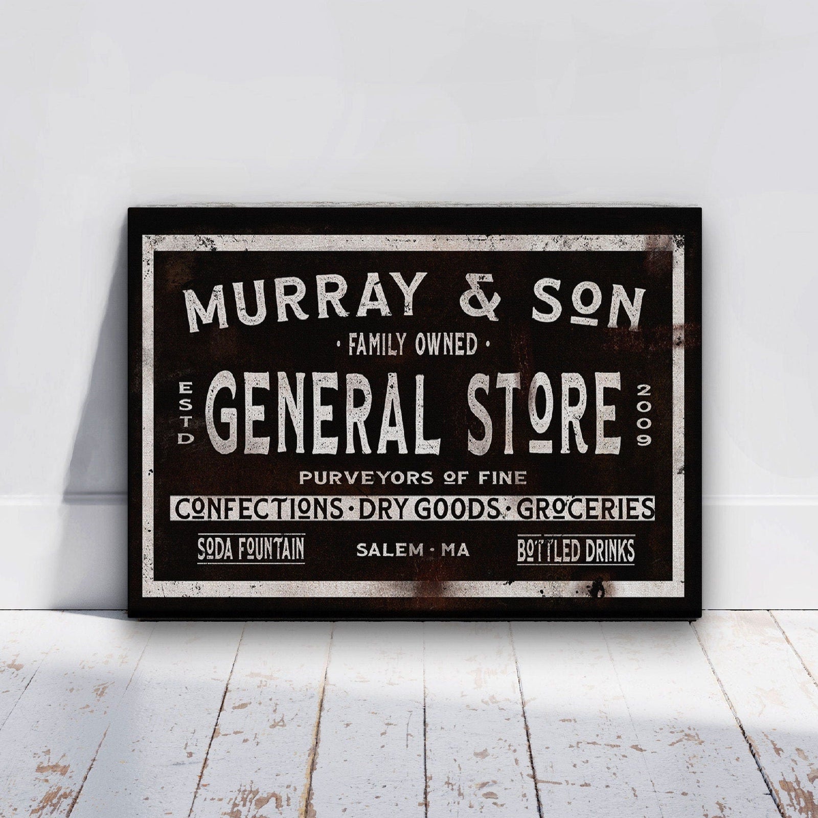 Vintage-style general store sign with distressed black background and cream lettering, showing sample text "Murray & Son" and "Salem, MA" with established year 2009.