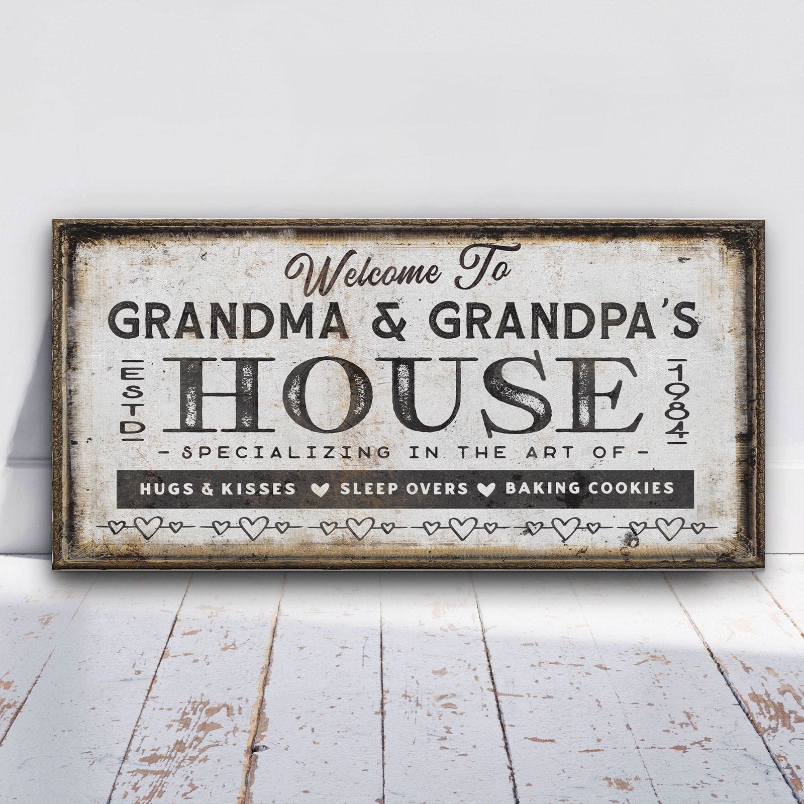 Distressed vintage canvas sign reading "Welcome To Grandma & Grandpa's House" with rustic frame and heart border, specializing in hugs, kisses, sleepovers, and baking cookies.