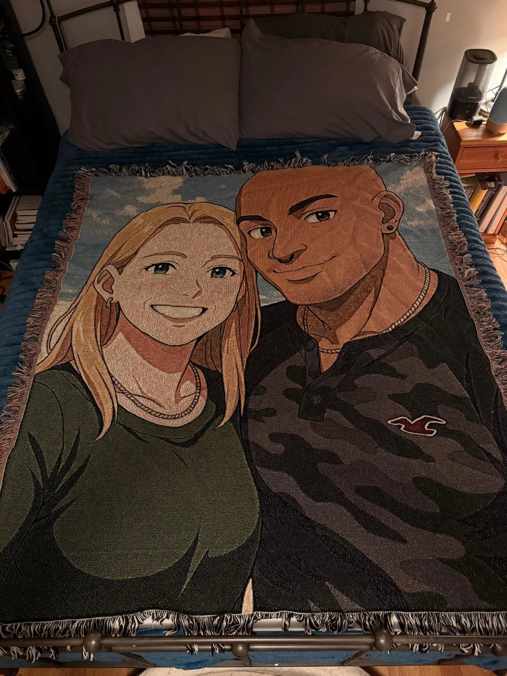 Personalized woven blanket with illustrated portrait of two people against a blue background, framed by woven fringe border