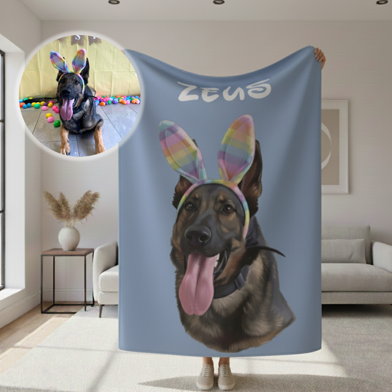Blue sherpa blanket printed with cartoon portrait of black dog wearing rainbow bunny ears and personalized with sample name "ZEUS" at top, displayed in living room setting with inset photo showing the reference dog image