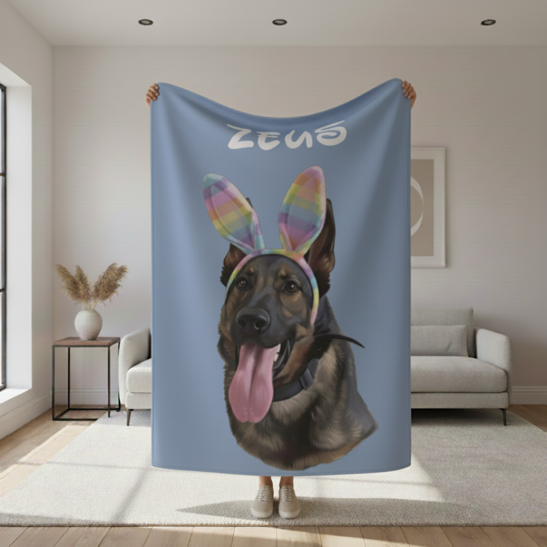 Blue sherpa blanket printed with a brown dog wearing rainbow bunny ears and sample name "ZENO" at the top, displayed in a modern living room setting.