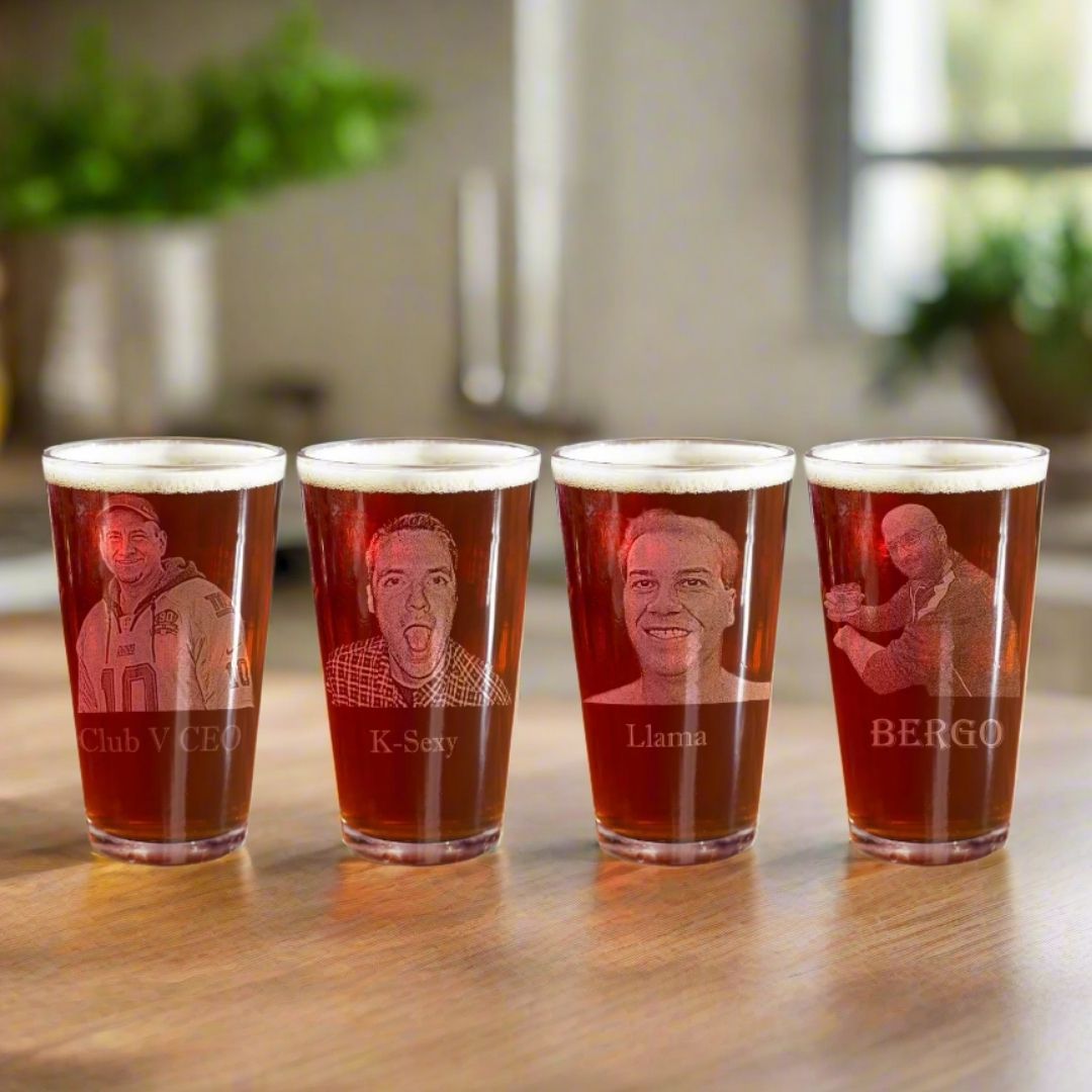 Four pint glasses with laser-engraved portrait photos and sample text labels "Club V CEO," "K-Sexy," "Llama," and "BERGO" displayed in a row on a wooden surface