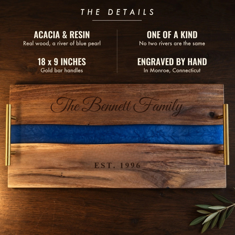 The details of the Blue River Serving Tray: acacia and blue pearl resin, one of a kind, 18 by 9 inches with gold handles, engraved The Bennett Family EST. 1996