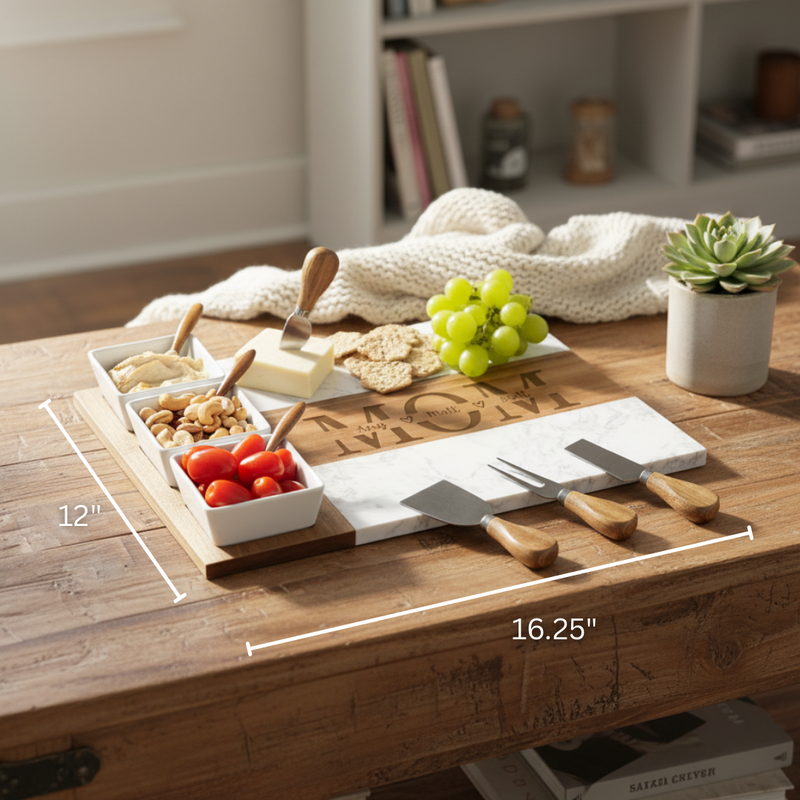 Personalized charcuterie board with sample names engraved in a circle around "MOM" at center, styled with ceramic bowls, cheese knives, fresh grapes, and crackers on wooden table