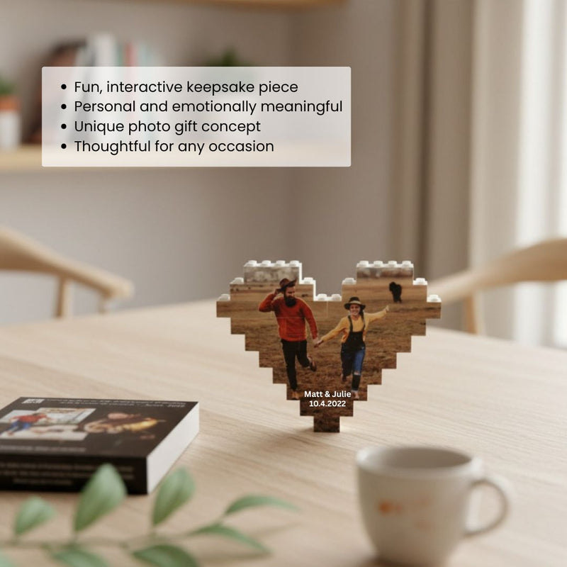 Heart-shaped wooden building block ornament displaying a photo of a couple holding hands, personalized with names Matt & Julie and date 10.4.2022, displayed on a wooden table
