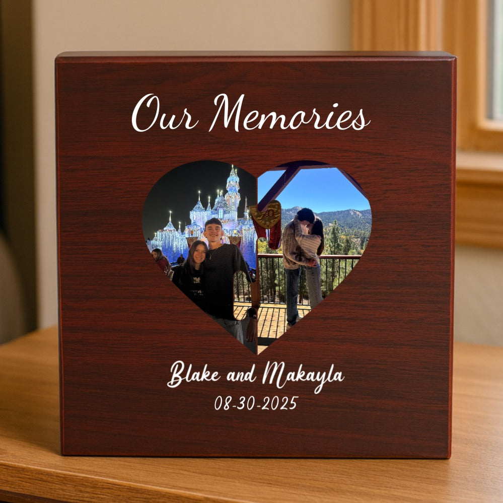 Dark wood keepsake box with heart-shaped photo window displaying sample photos, engraved with "Our Memories," sample names "Blake and Makayla," and date "08-30-2025