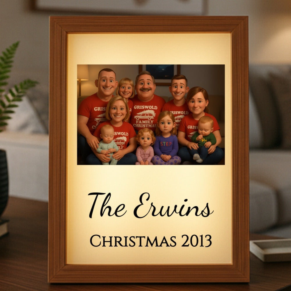 Wooden-framed light box displaying a family cartoon portrait with personalized text reading "The Erwins" and "Christmas 2013" on cream background