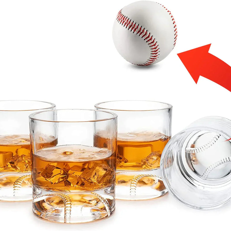 Four whiskey glasses filled with amber liquid and featuring baseball-stitched bases, displayed with a baseball-shaped decanter lid and a baseball above.