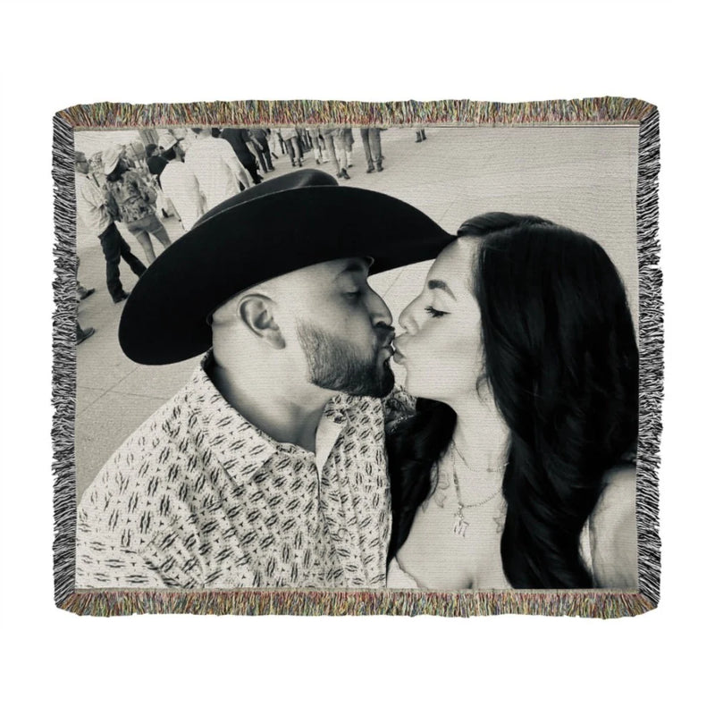 Black and white woven throw blanket featuring a couple kissing, displayed flat with multicolored fringe trim visible around all edges