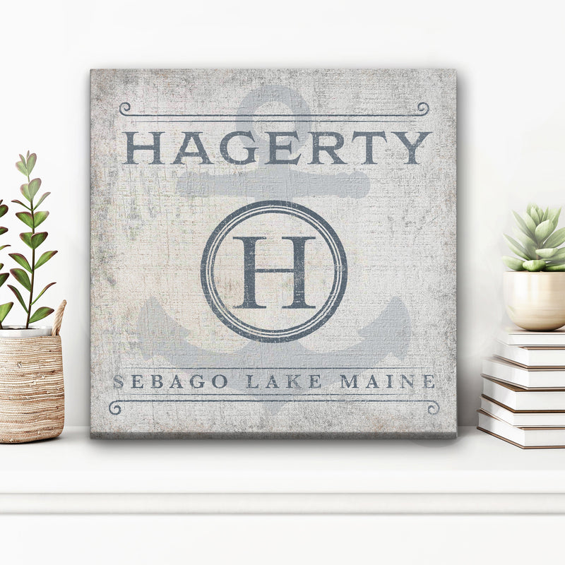 Canvas sign with personalized name "HAGERTY" at top, monogram initial "H" in circular badge, and "SEBAGO LAKE MAINE" text below on distressed white background