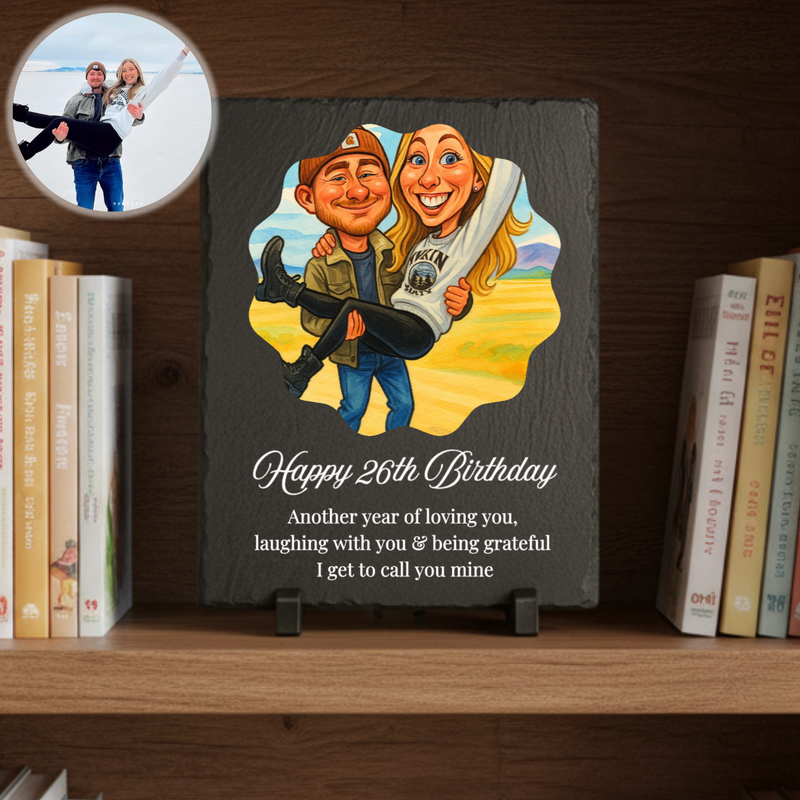 Personalized slate plaque displayed on wooden shelf showing caricature of couple with "Happy 26th Birthday" text and custom message, with reference photo in circular inset above.