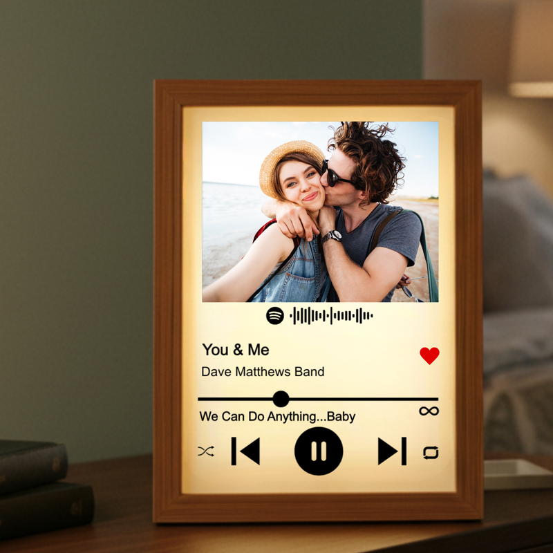 Wooden frame displaying a couple's beach photo with customized Spotify song code showing "You & Me" by Dave Matthews Band and sample lyrics "We Can Do Anything...Baby