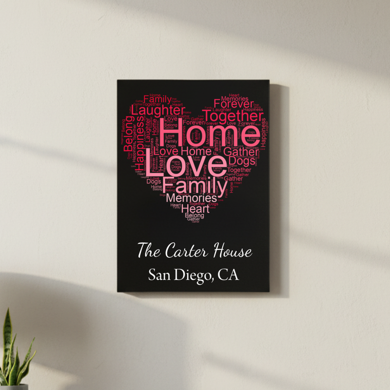 Black home decor sign with heart-shaped word cloud in pink and gray text reading "home," "love," "family," "memories," and "together," personalized with sample text "The Carter House" and "San Diego, CA" below in white script and serif fonts.