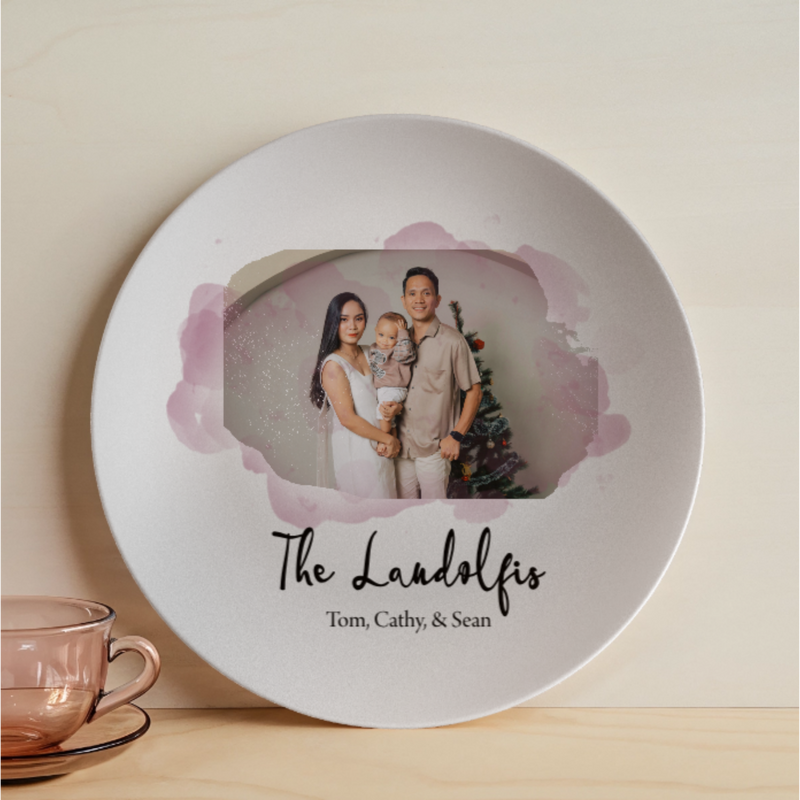 White ceramic plate with pink watercolor design framing a family photo sample, personalized with "The Landolfis" and names "Tom, Cathy, & Sean