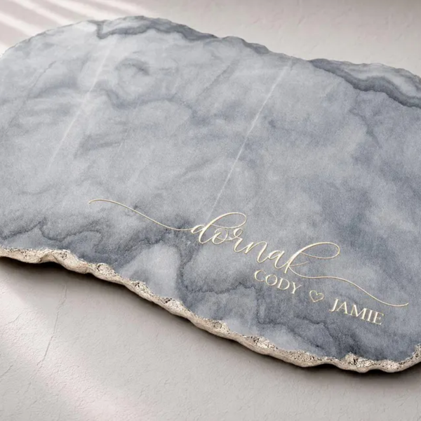 Marble charcuterie board with a hand-applied gold-leafed edge, engraved with the couple's names "Cody & Jamie" in elegant script