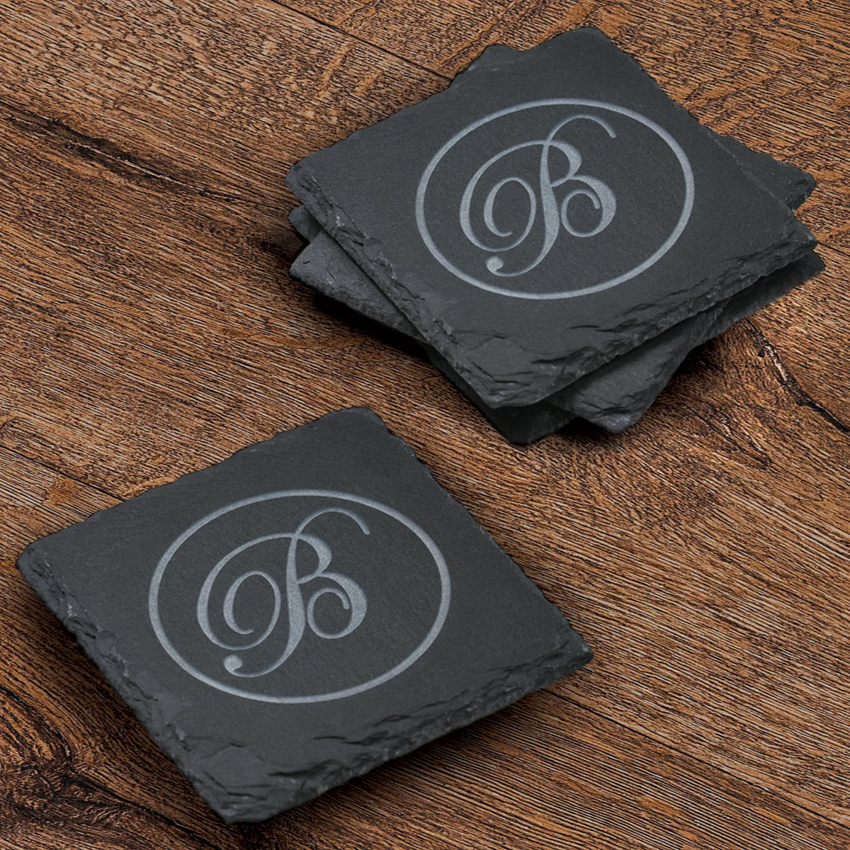 Square Natural Slate Coasters with engraved script monogram on wood table