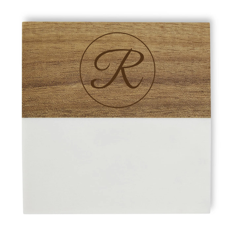 Wood coaster with engraved monogram sample "R" inside a circular border, paired with a white coaster base.