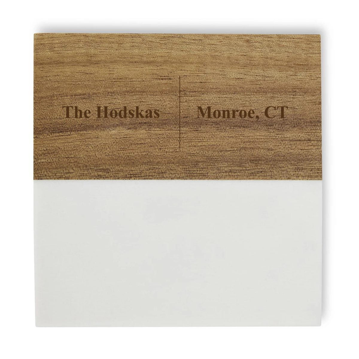 Wooden coaster with sample personalization reading "The Hodskas" and "Monroe, CT" engraved on natural wood surface with white base