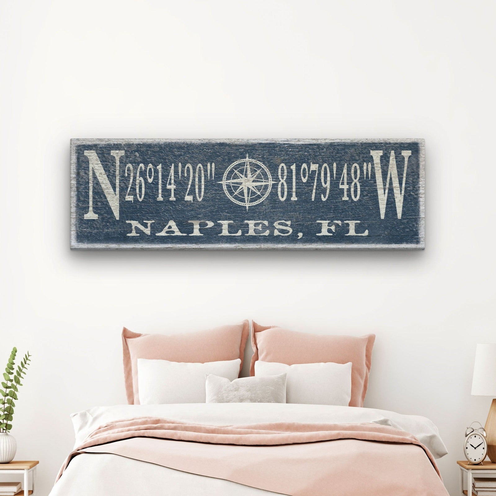 Personalized Compass Rose Canvas displaying GPS coordinates flanked by large N and W letters with a compass rose illustration at center and "Portland, Maine" at the bottom, in cream lettering on a distressed teal painted wood background, mounted above a kitchen shelf