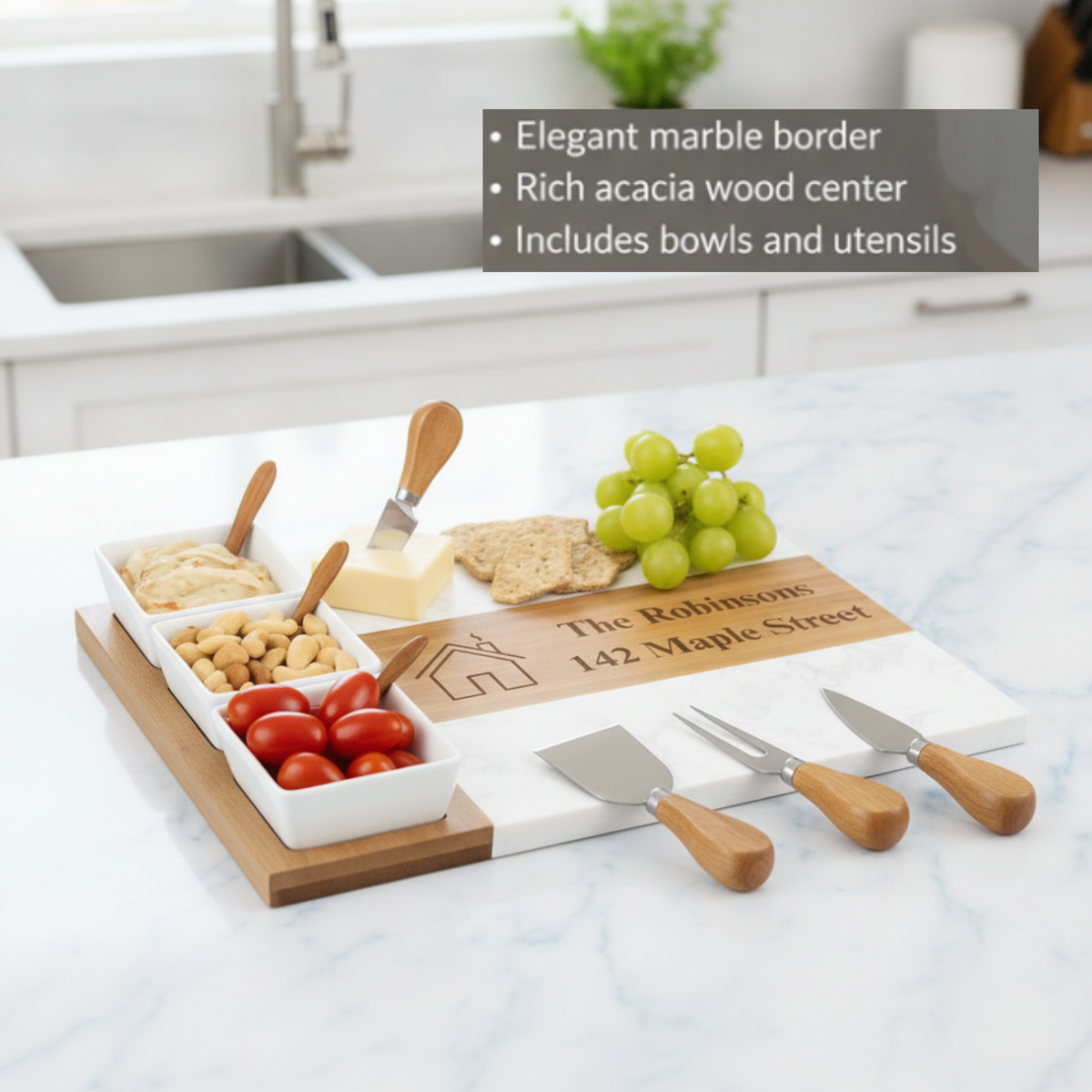Personalized charcuterie board with acacia wood base, marble center section, white ceramic bowls filled with snacks, sample engraving reading "The Robinsons 142 Maple Street," and wooden-handled serving utensils displayed on marble countertop.