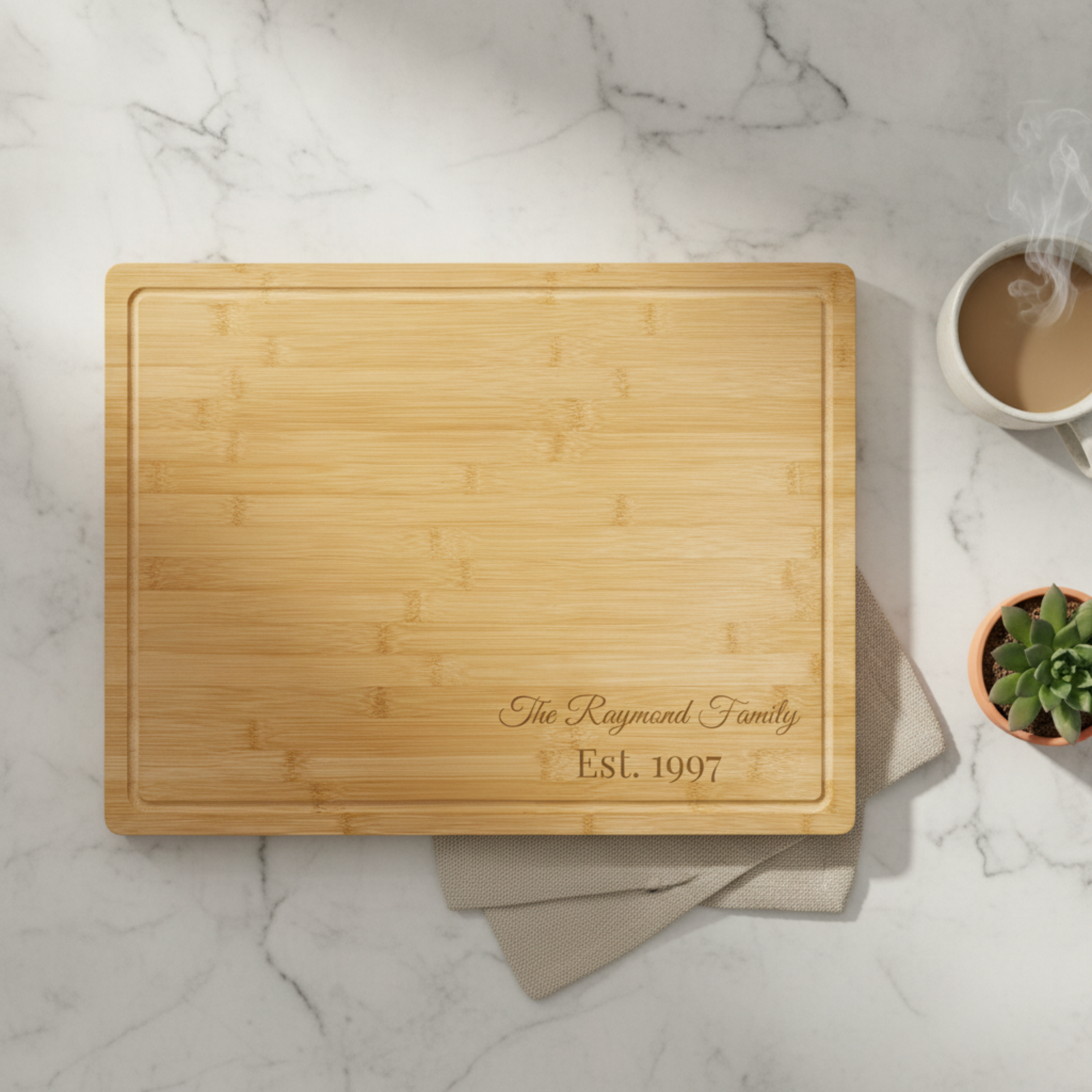 Large personalized bamboo cutting board engraved with family name, with deep drip ring, on kitchen counter