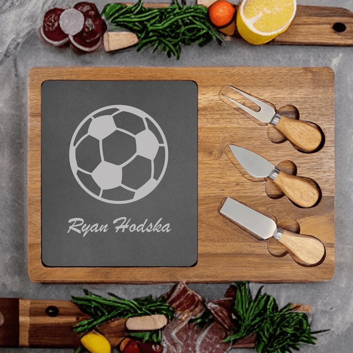Personalized Soccer Charcuterie Board engraved with a soccer ball and a custom name on a slate and acacia wood board with cheese knives
