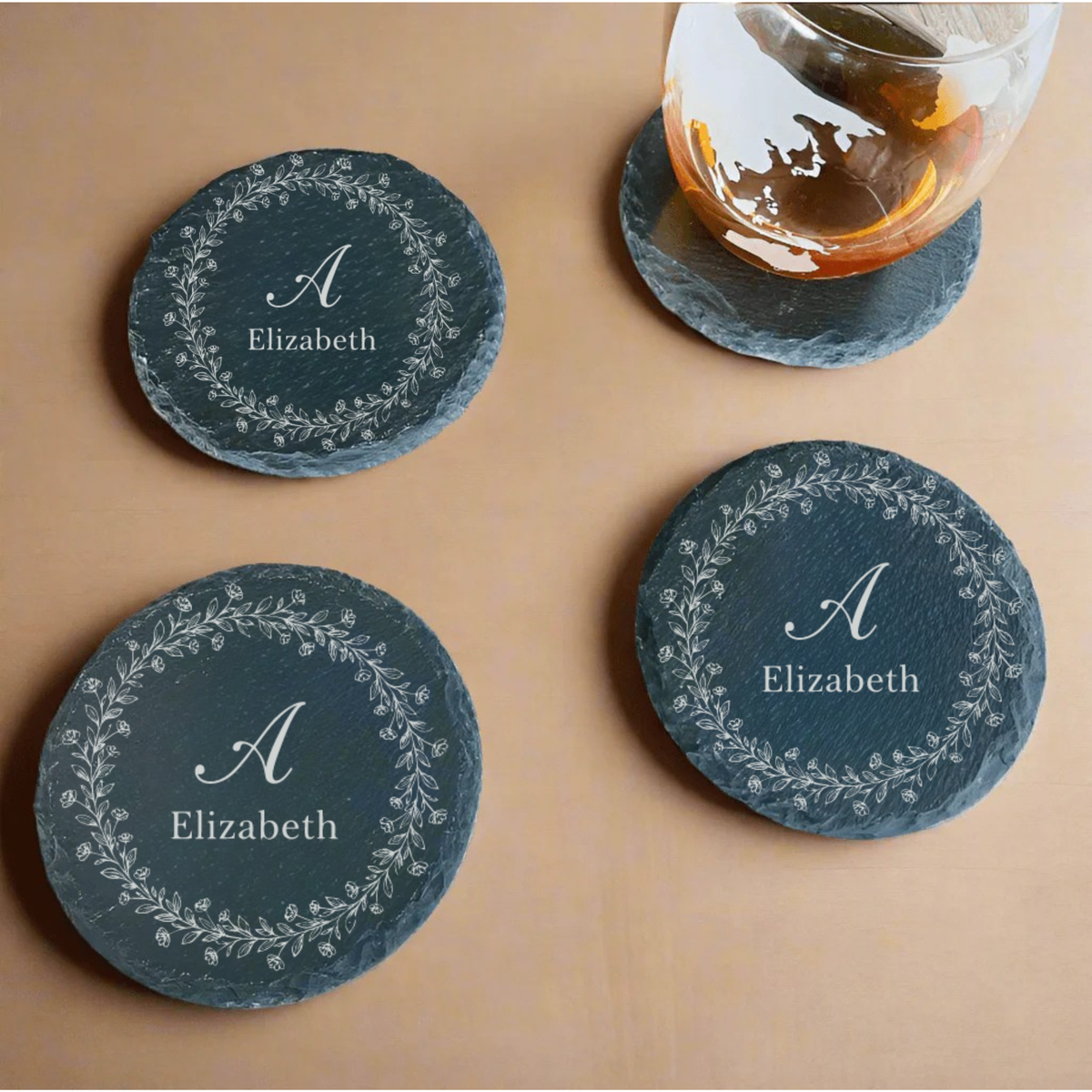 Personalized Round Slate Coasters with Floral Initial Engraving on Marble Table