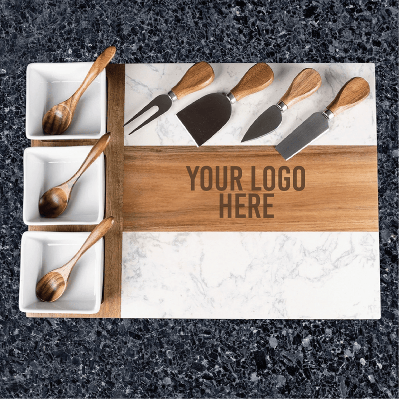 Marble and acacia wood charcuterie board with three white bowls and cheese knives, showing sample logo engraving area on wooden center band