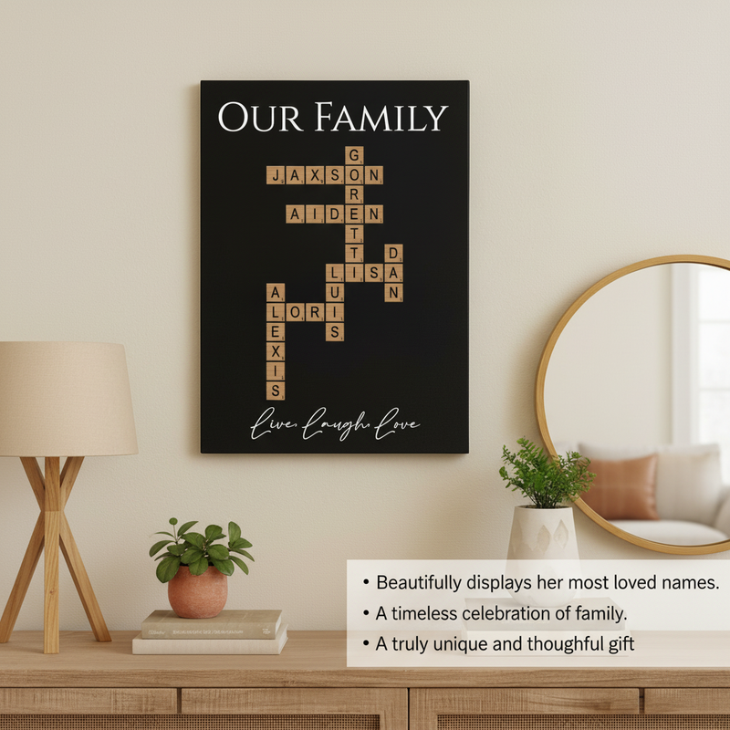 Black wall art displaying sample family names "Jaxson," "Aiden," "Garrett," "Lisa," and "Alexis" arranged in crossword pattern with wood-grain tiles, tagline "Live Laugh Love" below, displayed above wooden dresser with lamp and mirror.
