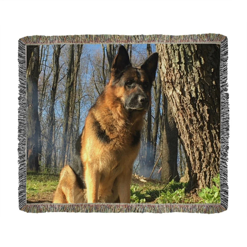 Woven photo throw blanket featuring a German Shepherd sitting in a wooded area, displayed flat with gray fringe edging visible around the border