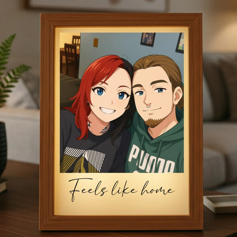 Wooden-framed anime-style portrait light box displaying two characters with red and brown hair, inscribed with "feels like home" text below the illustration