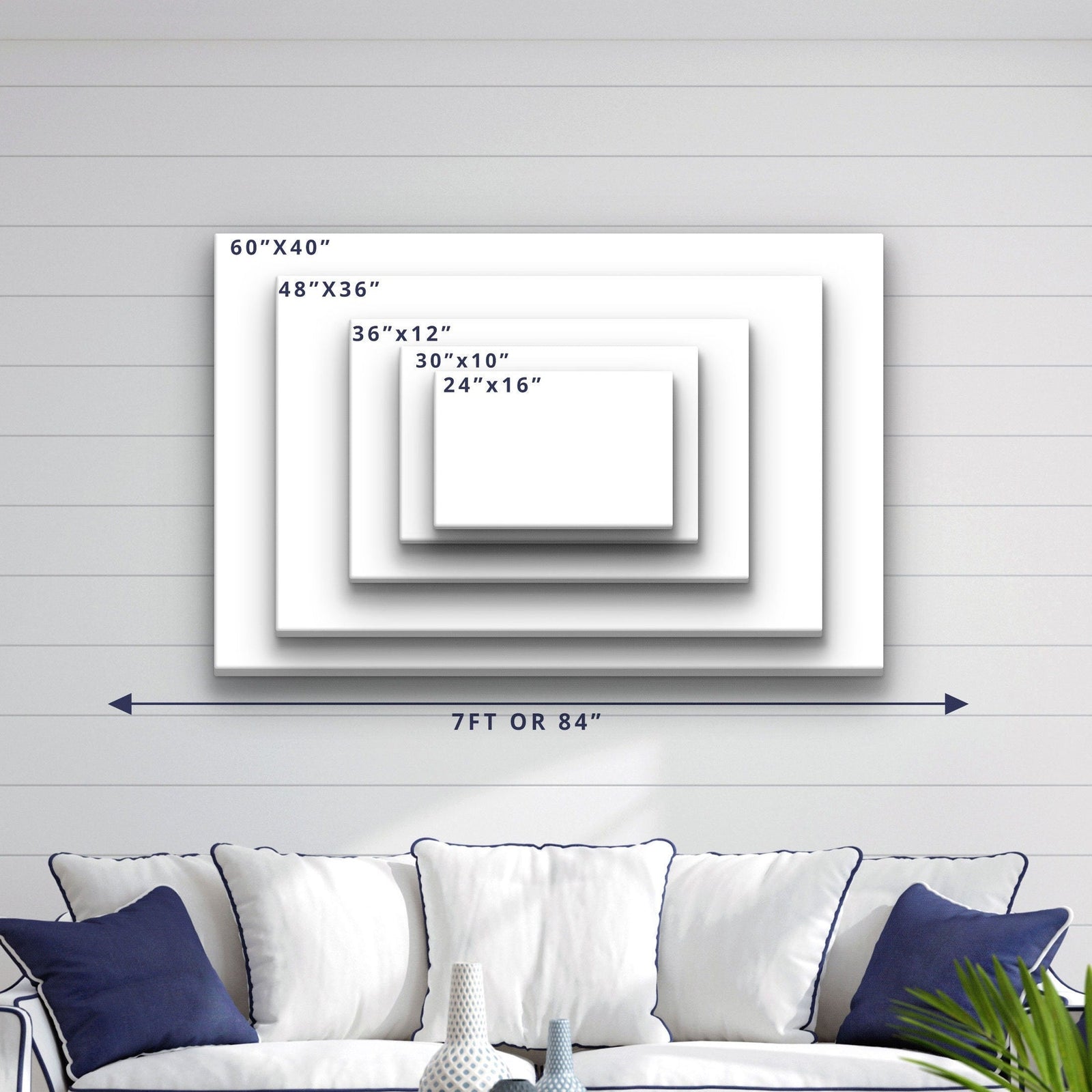 Size comparison chart showing five canvas dimensions from 24"x16" to 60"x40", displayed on shiplap wall above a navy and white upholstered sofa