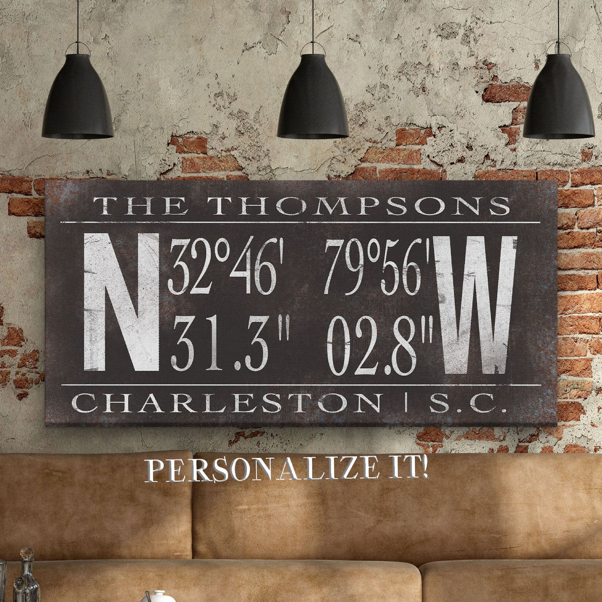 Personalized Family Coordinates Canvas displaying "The Thompsons" at the top above large N and W compass letters flanking bold GPS coordinates and "Charleston | S.C." at the bottom, in white lettering on a distressed dark charcoal metal background, mounted on an exposed brick wall