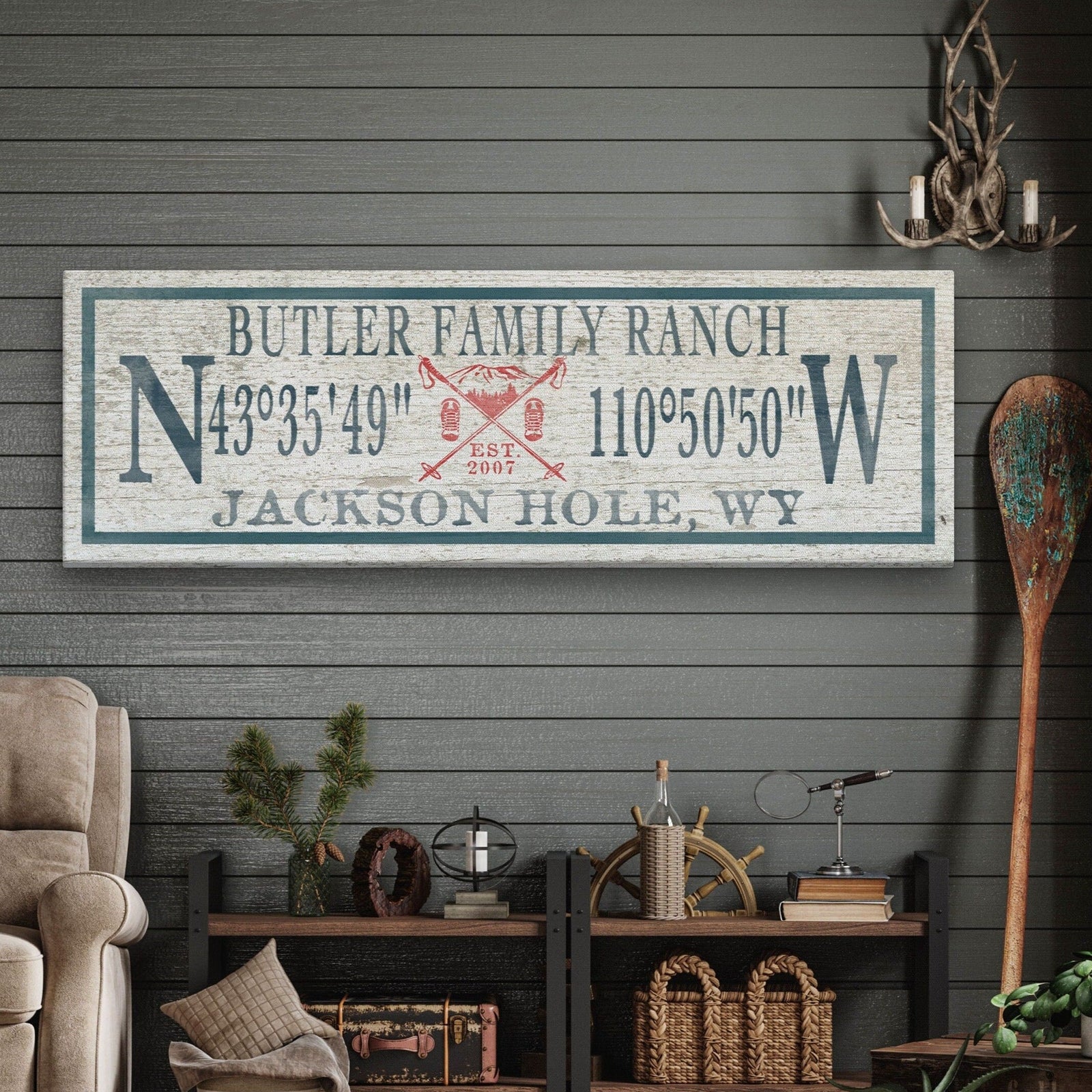 Personalized Canvas Ski Lodge Sign displaying "Jones Family Cabin" above GPS coordinates flanked by large N and W compass letters, with a crossed ski poles and mountain illustration reading "Est. 2007" and "Woodstock, Vermont" at the bottom, on a distressed cream wood background with a slate border