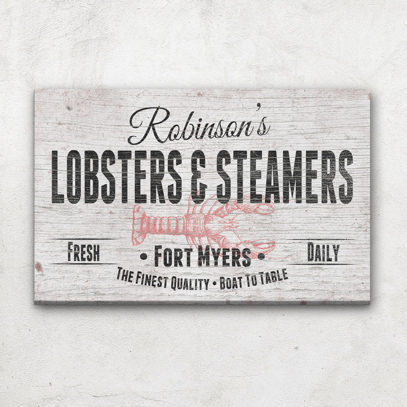 Personalized canvas sign with sample name "Robinson's" at top, "Lobsters & Steamers" in bold text, red lobster illustration, and "Fort Myers" location text on distressed white wood background.