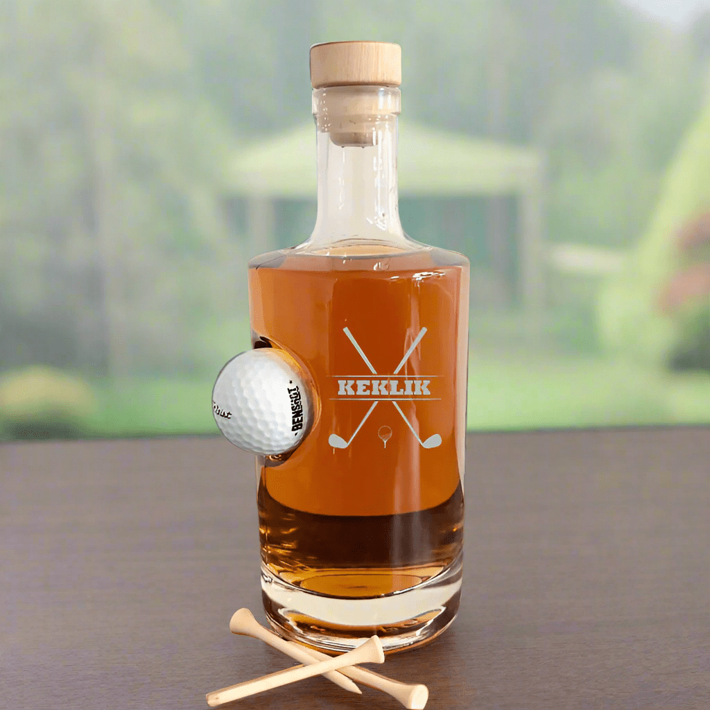 Personalized glass golf decanter with an embedded golf ball, engraved with "KEKLIK" and crossed golf clubs design. Willow and HIve